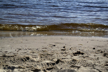Wet sand and soft waves on a beach.