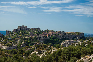 Fototapeta na wymiar Panoramic view of the village and ruins of the Baux-de-Provence Castle on top of cliff and sunny blue sky. Bouches-du-Rhone department, Provence-Alpes-Côte d'Azur region, southeastern France