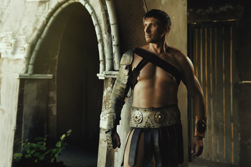 The muscular man in Roman armor. gladiator in armour. concept of masculinity, determination, strength