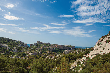 Fototapeta na wymiar Panoramic view of the village and ruins of the Baux-de-Provence Castle on top of cliff and sunny blue sky. Bouches-du-Rhone department, Provence-Alpes-Côte d'Azur region, southeastern France