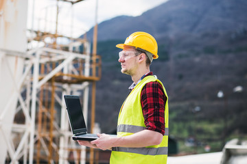 Construction worker or engineer using laptop