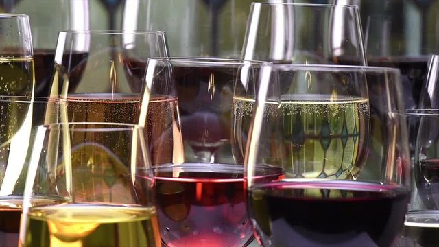 Champagne, white, rose and red wine and drinks in glasses on stained glass background, France