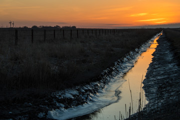 leuchtend oranger Flusslauf im Sonnenuntergang