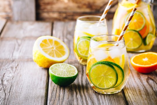 A refreshing summer ice-cold drink. White wine sangria in glass with lime, lemon and orange