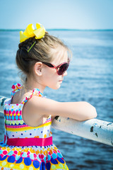 Beautiful child with glasses have a ship waiting on the pier