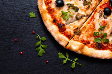 Homemade Napoli Pizza or anchovies pizza on black slate stone