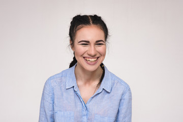 Fototapeta premium Portrait of a happy beautiful young brunette girl on a white background.