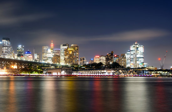 Colorful light reflections on the water from the central business district in Sydney, Australia at night