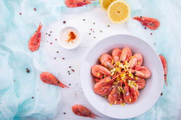 Boiled shrimps, are served with sauce and a lemon