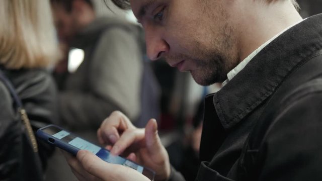 Young handsome businessman with smartphone in subway, man student use phone in train transportation with people peak rush hour