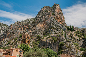 Fototapeta na wymiar View of the church Notre-Dame de Beauvoir amid the cliffs and houses of the charming village Moustiers-Sainte-Marie. In the Alpes-de-Haute-Provence department, Provence region, southeastern France