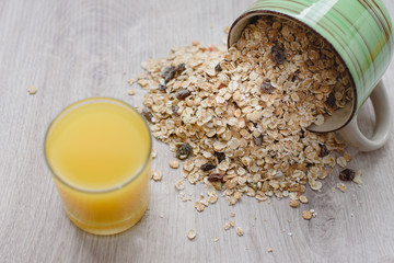 Still life healthy breakfast of muesli and orange juice in a glass on a wooden background.