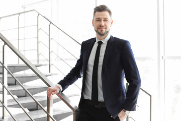 Male lawyer standing near stairs in office