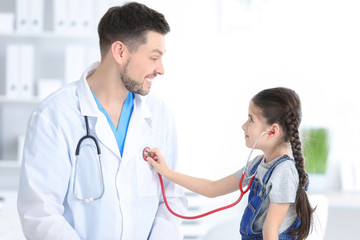 Children's doctor with little girl in hospital