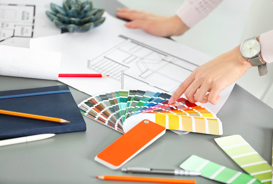 Female designer working with color palette samples at table