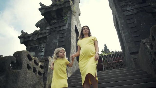 Pregnant girl with happy kid in Besakih temple in Bali sundawn rapid slow motion