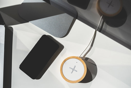 Mobile Phone And Wireless Charger On Office Table