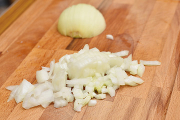 Finely chopped fresh onion on a cutting board in the kitchen. Close-up