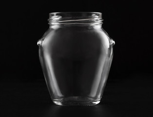Transparent glass empty jar on a black background