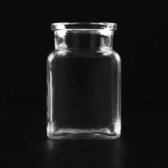 Transparent glass empty jar on a black background