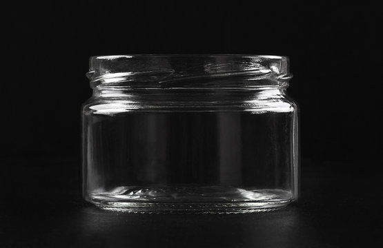 Transparent glass empty jar on a black background