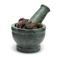 Organic Indian Chhoti Harad fruit (Terminalia chebula) on marble pestle and over white background.