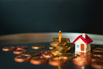 Miniature people, woman sitting on stack coins using as business and property concept