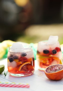 Summer cooling drink detox water from citrus lime, lemon, red orange, berries and ice cubes on outdoor