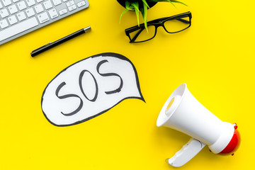 Ask for help concept. Megaphone near cloud with word SOS on yellow background top view