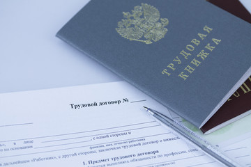 Трудовая книжка и договор с ручкой.
