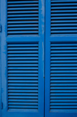 Blue window shutters. Mediterranean window with blue wooden shutters and wall background with copy space. Vintage background. Cyprus