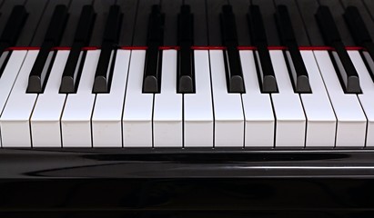 Grand piano keyboard, black and white, ivory and ebony, reflection on the lid, perspective