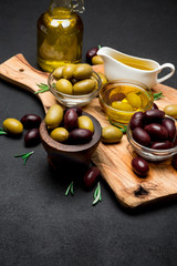 black and green olives and oil on wooden cutting board