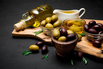 black and green olives and oil on wooden cutting board