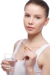 Beautiful young woman holding fish oil pill in your hand. Healthy eating concept.