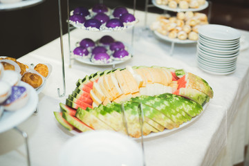 Delicious and tasty dessert table with cupcakes shots at reception closeup