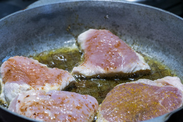 Meat is fried in a frying pan