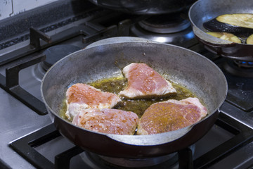 Meat is fried in a frying pan