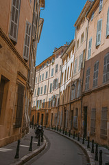 Narrow alley with tall buildings in the shadow in Aix-en-Provence, a pleasant and lively town in...