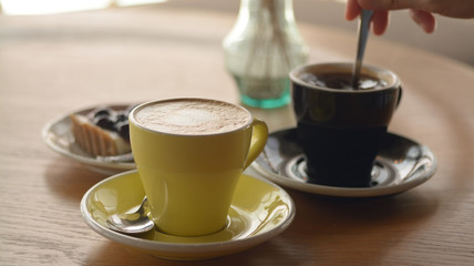 Cup of coffee and blueberry cheese pie on table in cafe
