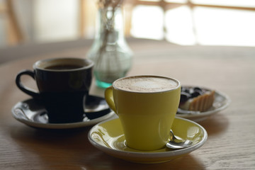 Cup of coffee and blueberry cheese pie on table in cafe