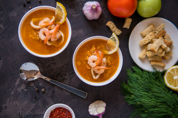 Lentil soup with seafood. Red soup with shrimps and squid top view