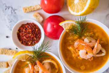 Lentil soup with seafood. Red soup with shrimps and squid top view