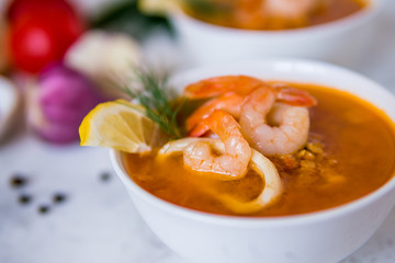 Lentil soup with seafood. Red soup with shrimps and squid, copy space