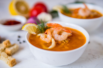 Lentil soup with seafood. Red soup with shrimps and squid, copy space