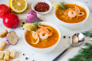 Lentil soup with seafood. Red soup with shrimps and squid, copy space