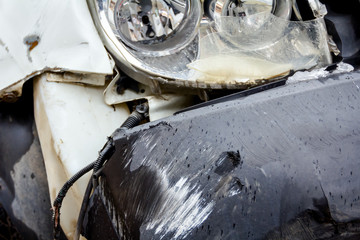 Broken headlamp on a white car after traffic accident