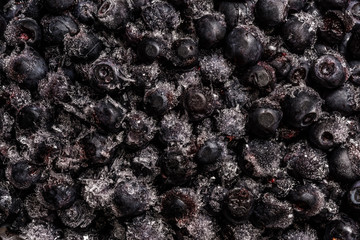 frozen blueberries covered with ice crystals, food background