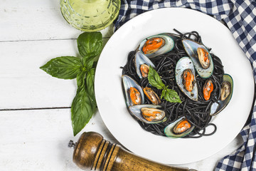 Black spaghetti. Black seafood pasta with mussels over black background. Mediterranean delicacy food.