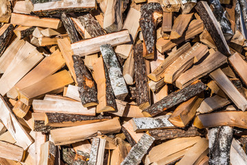 chaotically arranged in a pile of fresh chopped firewood, abstract background
